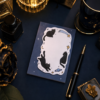 Carnet chat noir sur un bureau bleu nuit