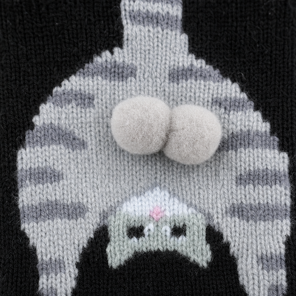 Gros plan sur le pompon des chaussettes chat noir
