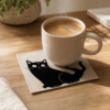 Dessous de verre chat noir sous une tasse de cafe