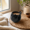 Mug chat noir en ceramique avec un cafe sur une table