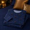 Pyjama chat noir plie sur un lit bleu nuit