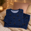Pyjama chat noir pose sur un lit cosy