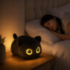 Veilleuse chat noir allumee sur une table de chevet